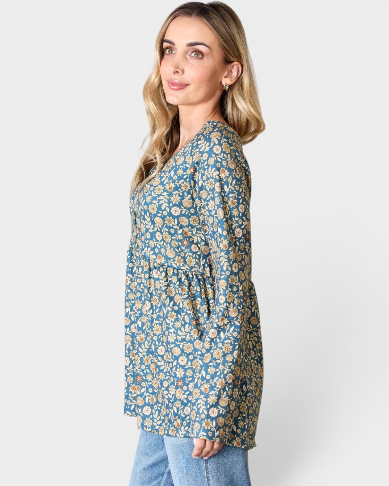 Woman wearing a blue floral blouse against a white background