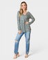 Woman wearing a floral long-sleeve top and blue jeans on a white background