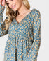 Woman wearing a blue floral dress with long sleeves on a white background