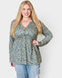 Woman wearing a floral blouse and jeans on a white background