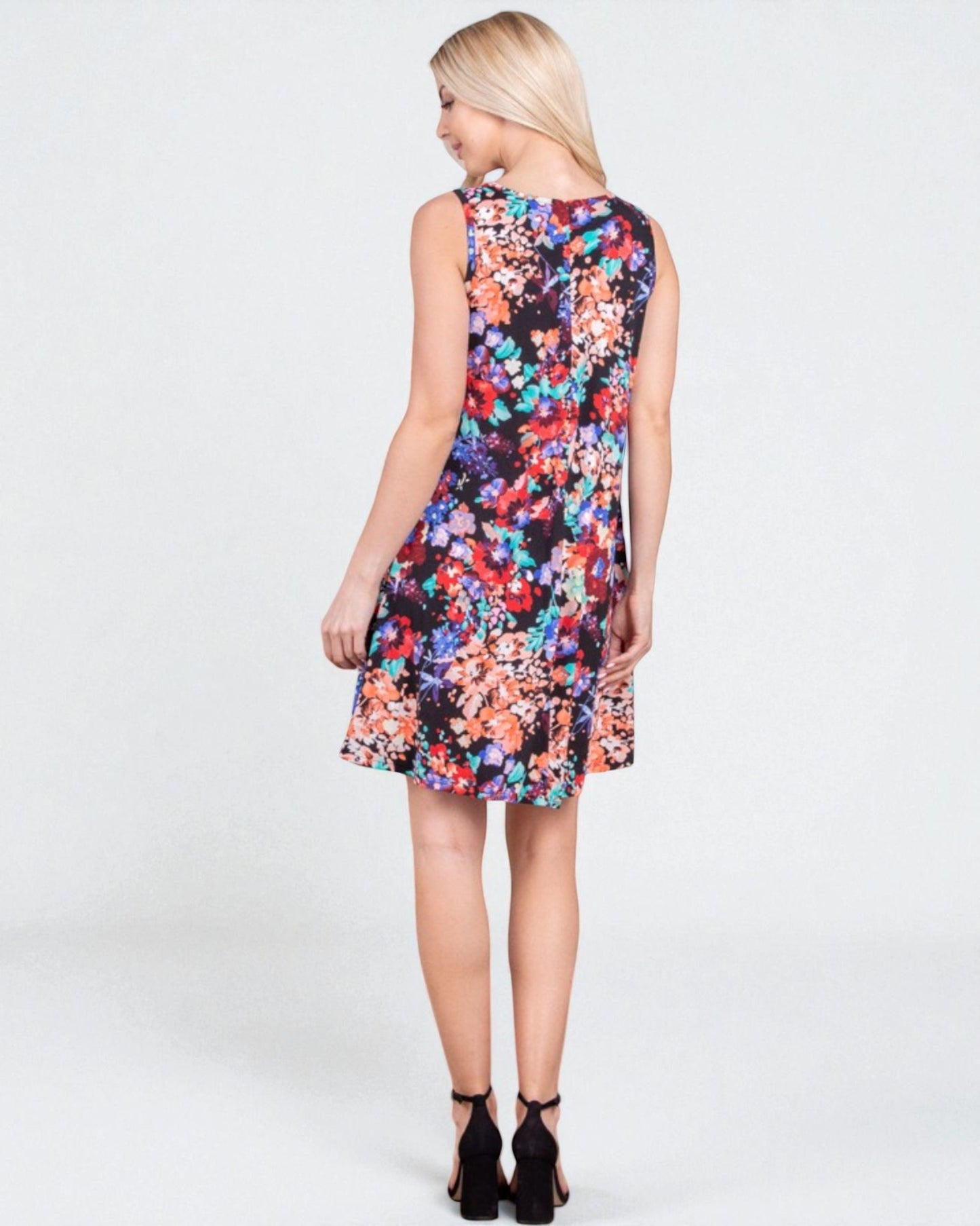 Woman wearing a colorful floral dress on a white background