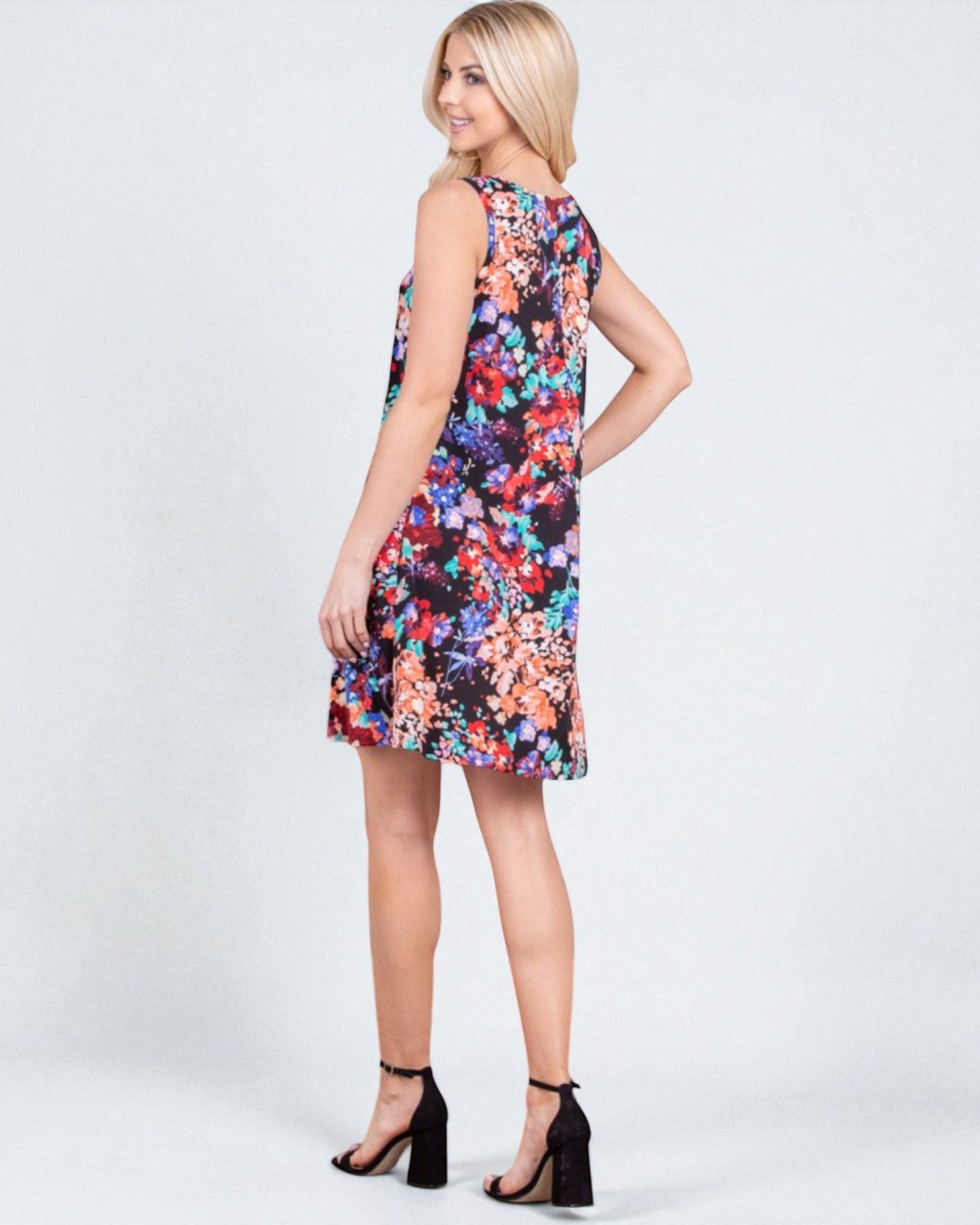 Woman wearing a colorful floral dress on a white background