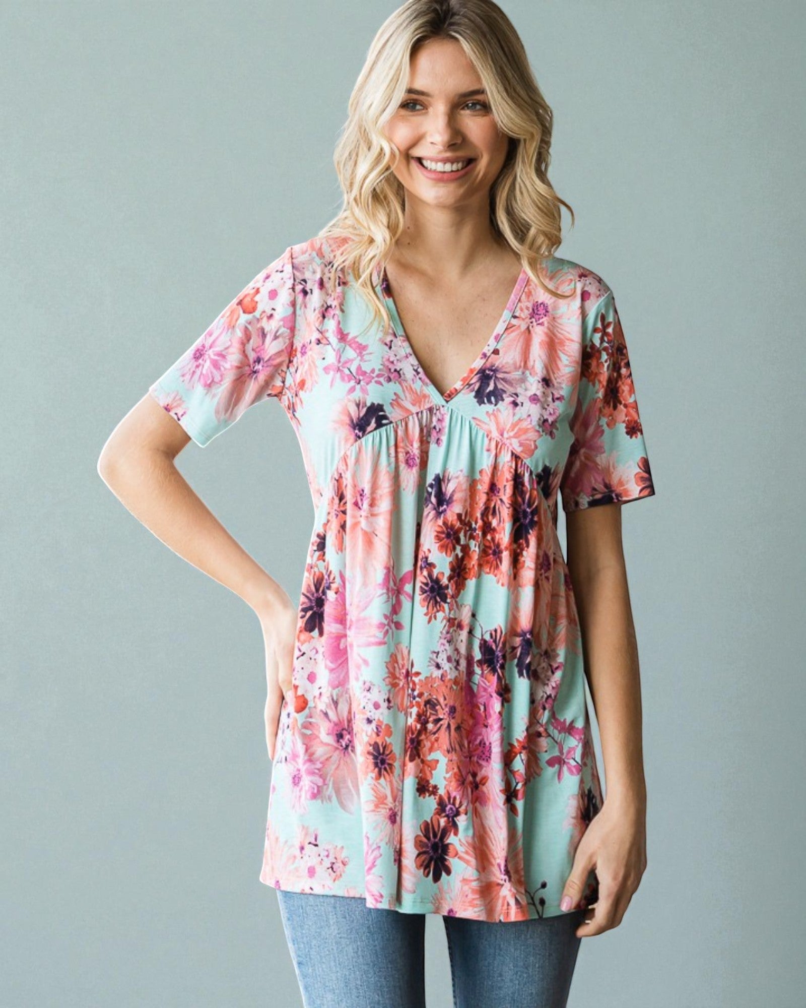 Woman wearing a floral print top against a gray background