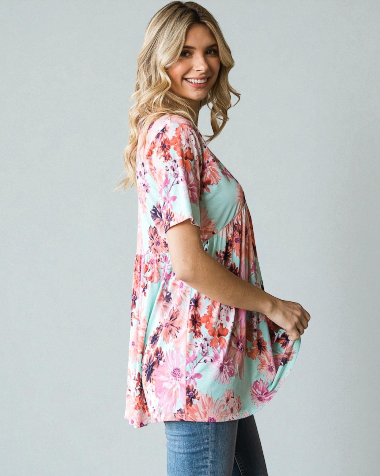 Woman wearing a floral kimono-style top against a plain background
