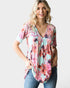 Woman wearing a floral blouse with a plain background