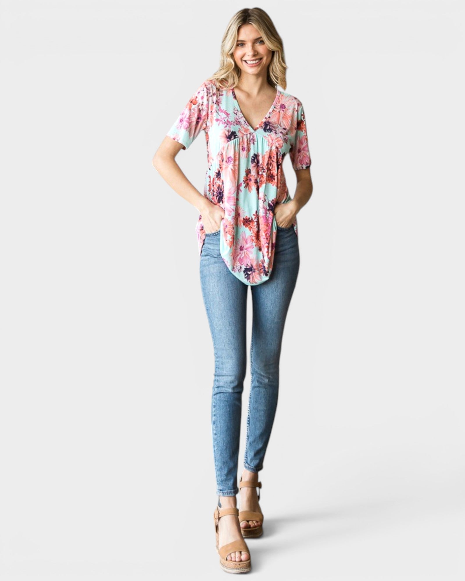Woman wearing a floral blouse and blue jeans on a white background