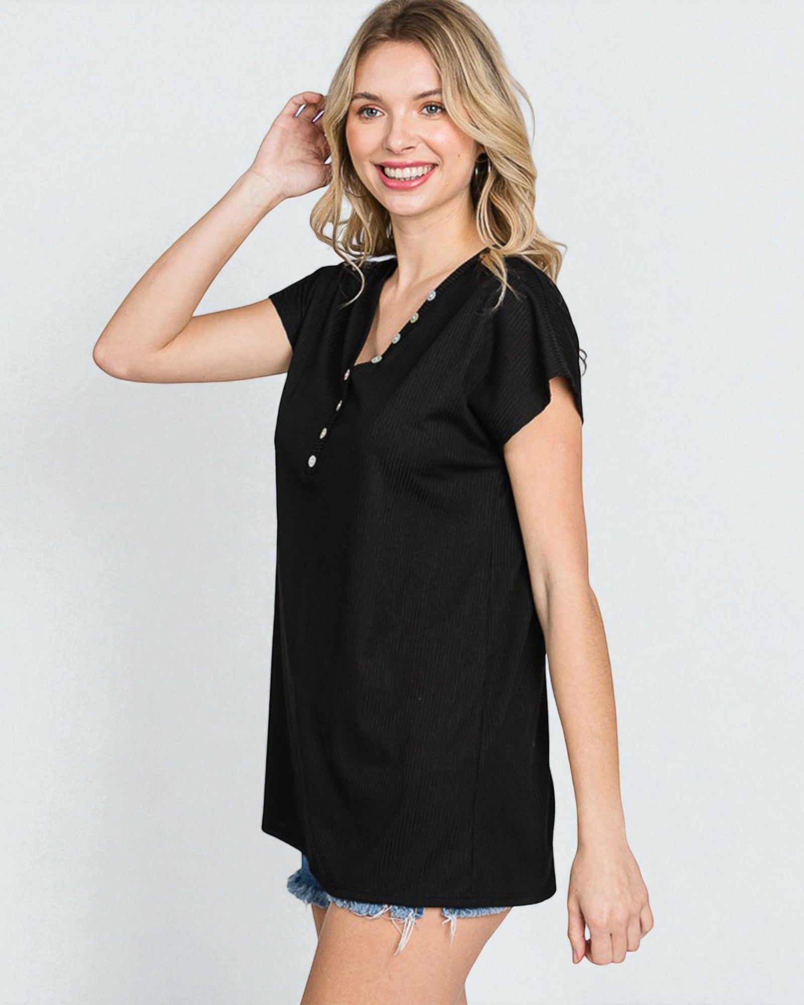 Woman wearing a black dress with buttons on a white background