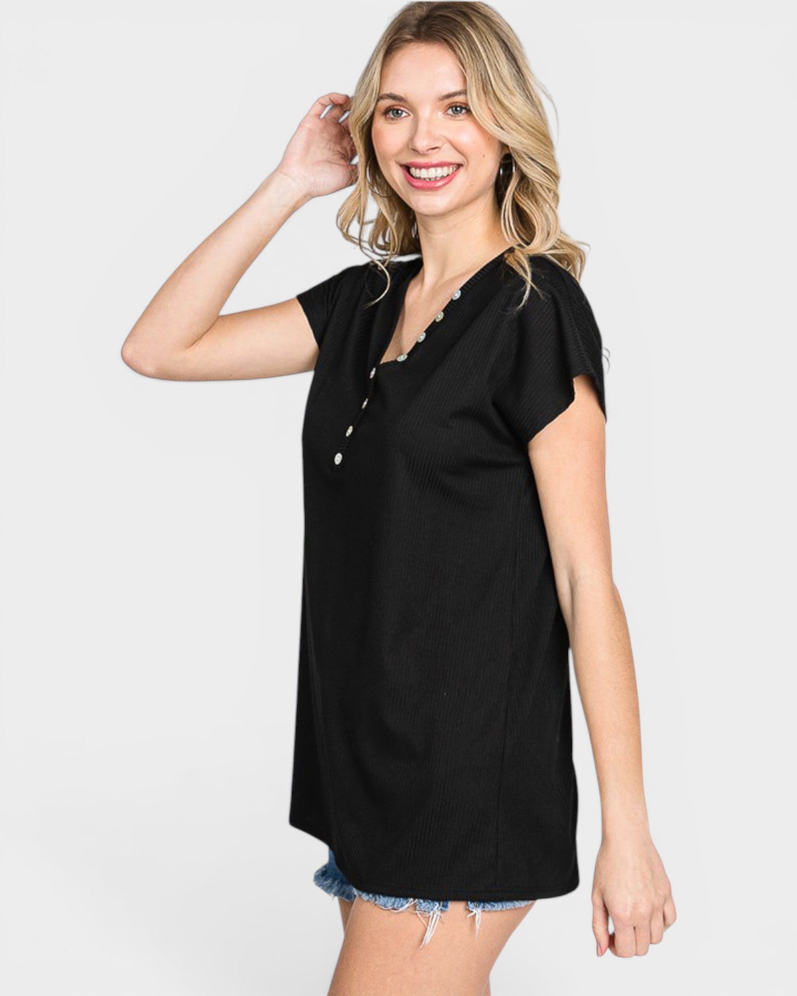 Woman wearing a black top with buttons on a white background