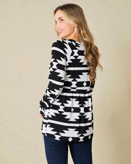 Woman wearing a black and white patterned cardigan against a beige background