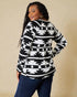 Person wearing a black and white patterned sweater against a beige background