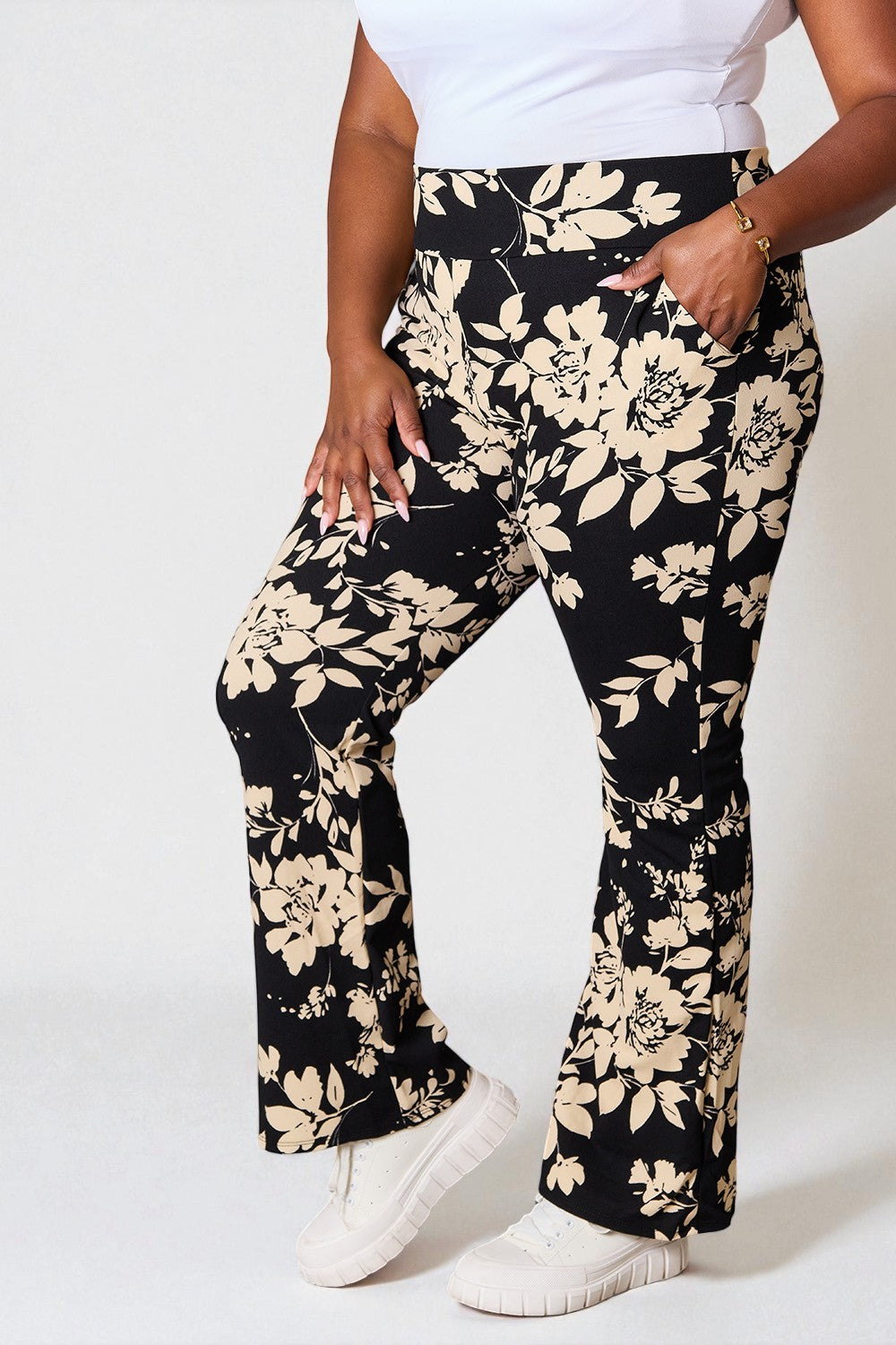 Person wearing black floral pants with a white background