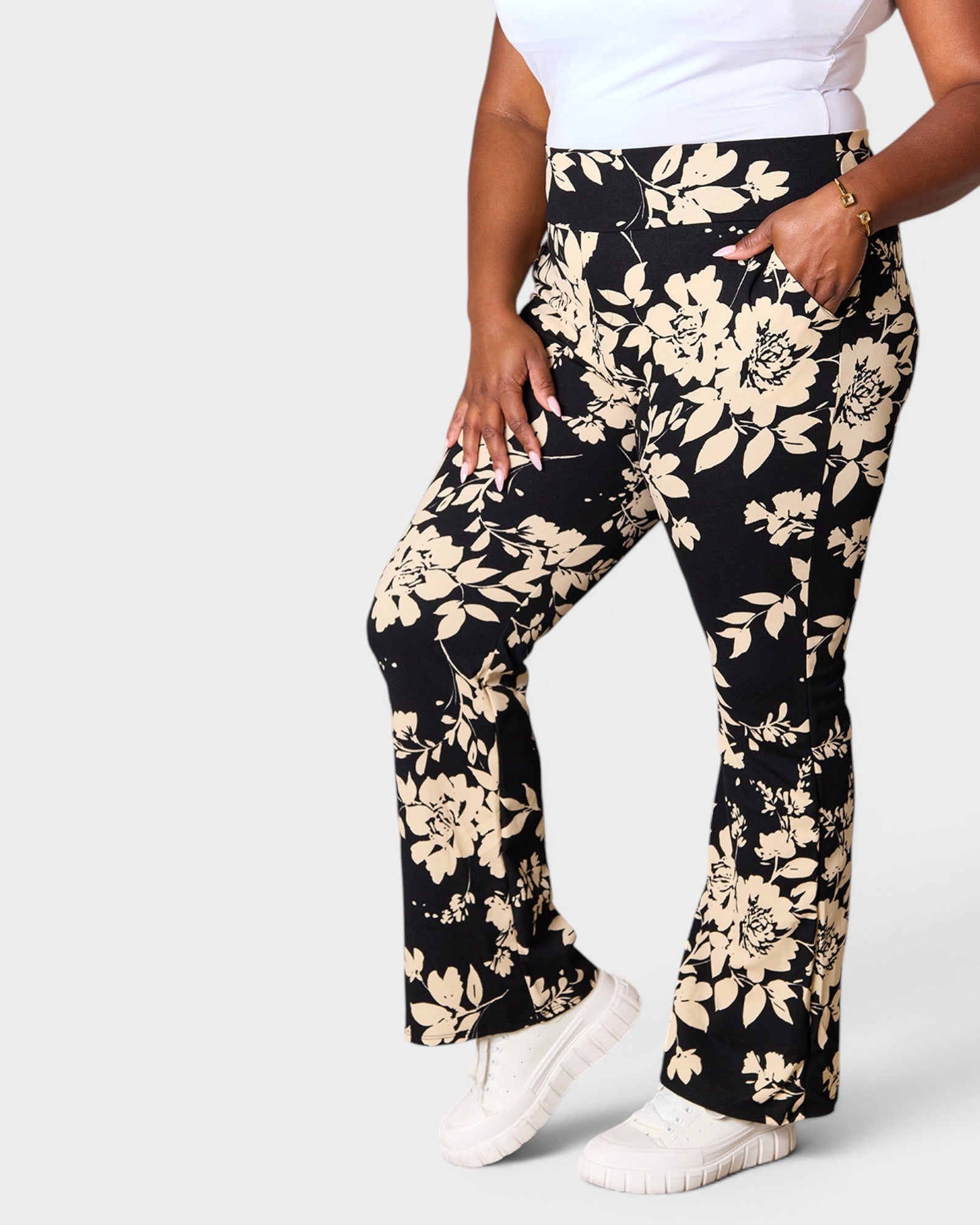 Person wearing black floral pants on a white background
