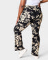 Black floral pants worn by a person on a white background