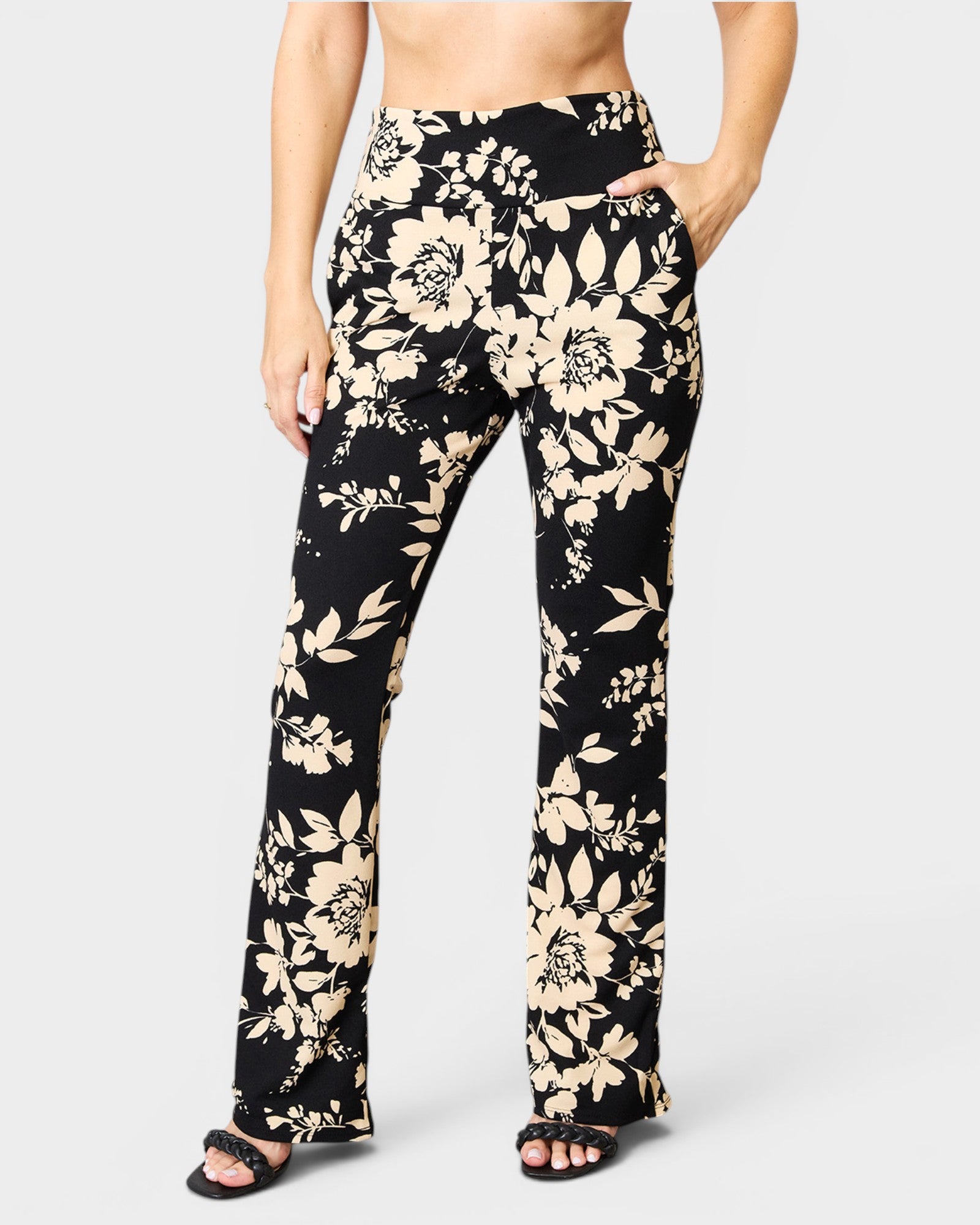 Black floral pants worn by a person on a white background