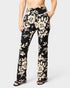 Black floral pants worn by a person on a white background