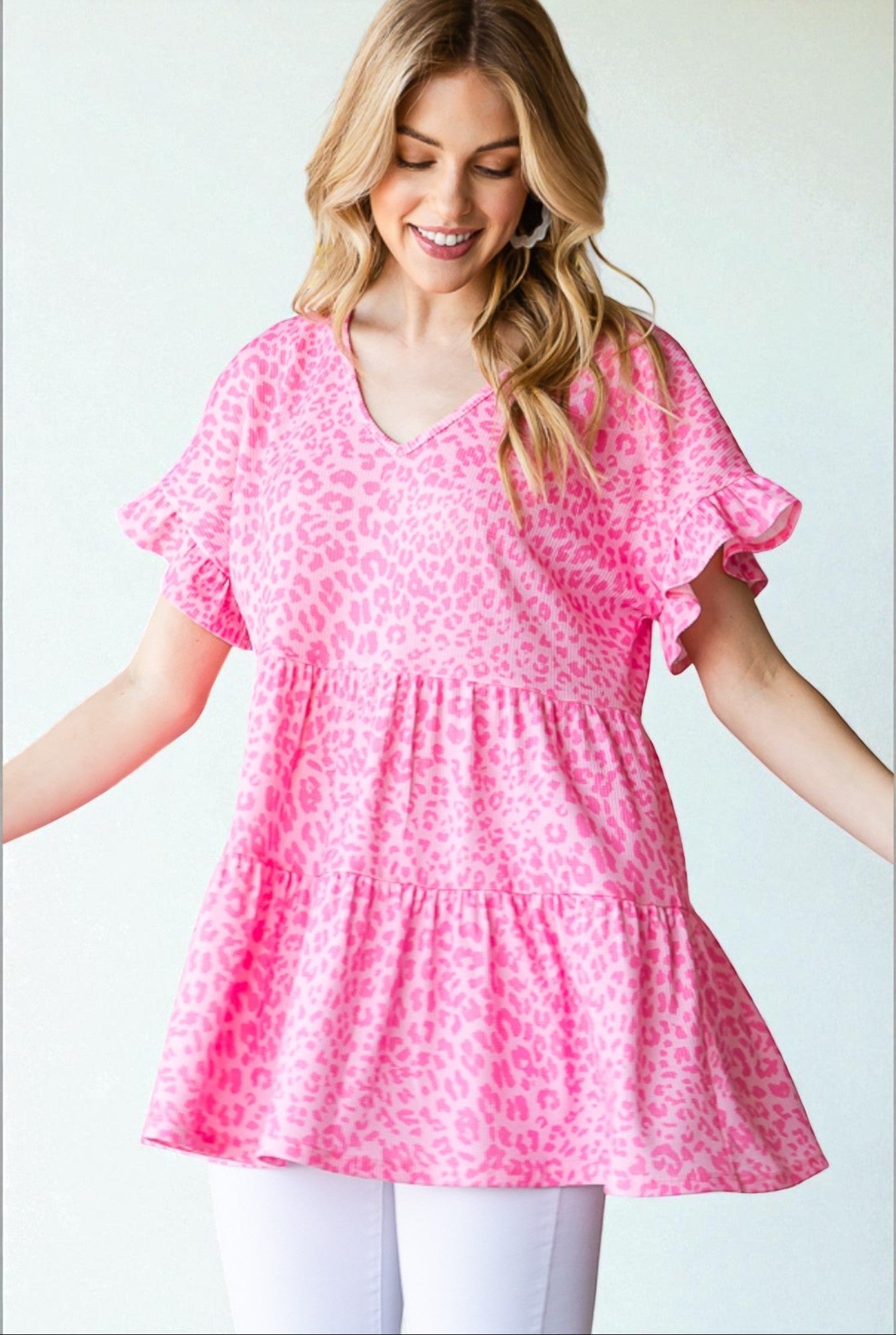 Woman wearing a pink leopard print dress against a light background