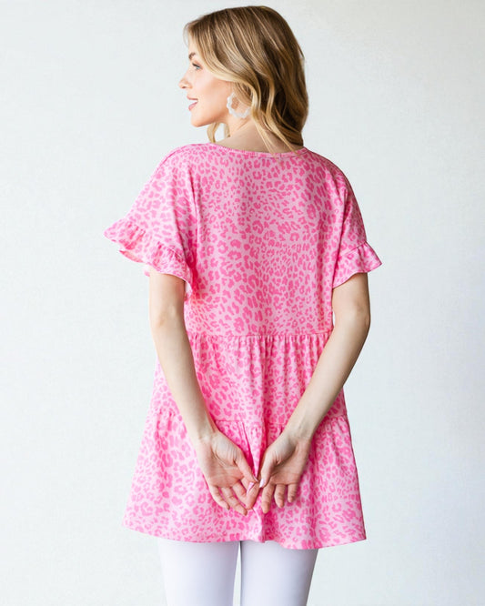 Woman wearing a pink patterned dress against a white background