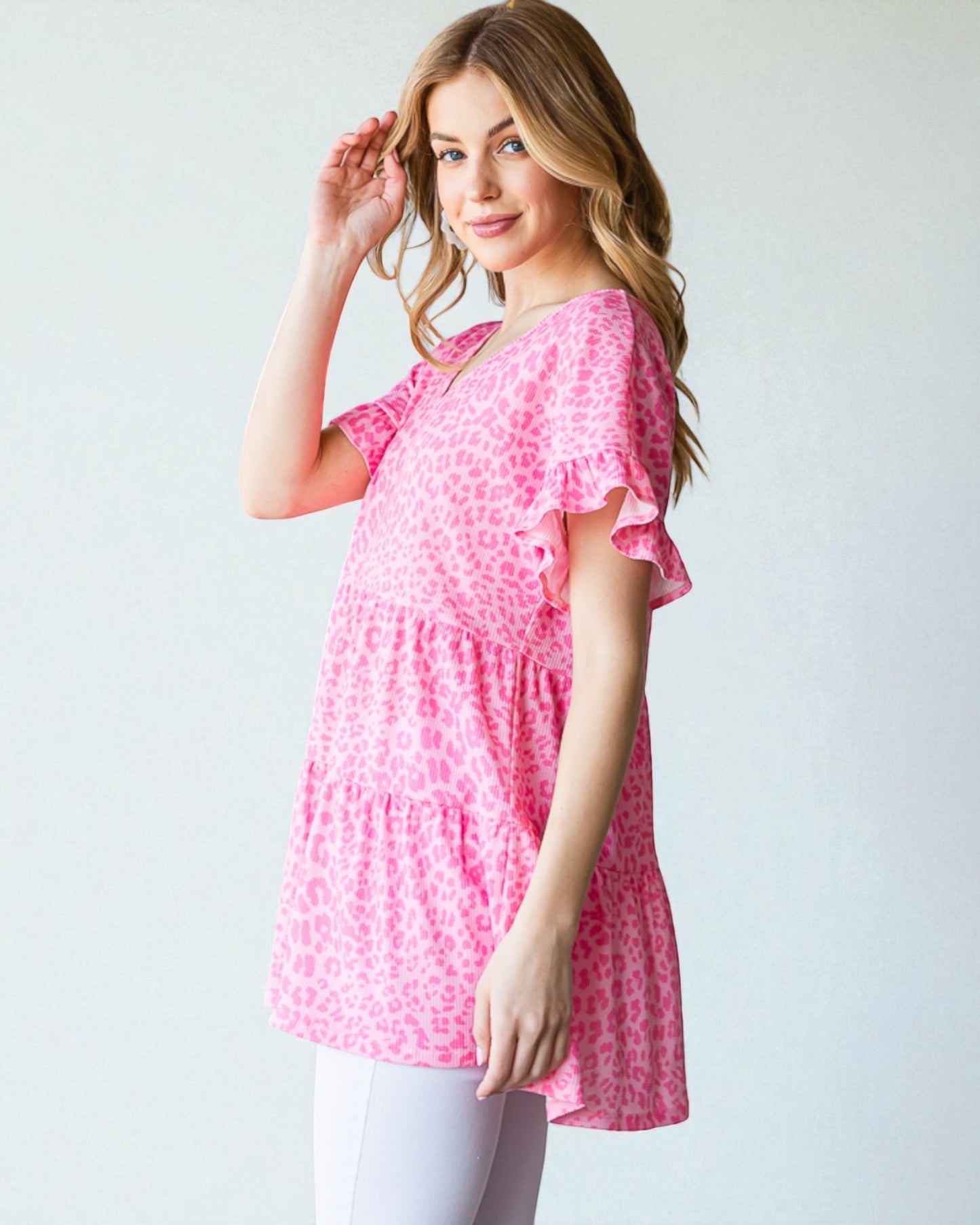 Woman wearing a pink patterned dress against a white background