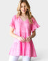 Woman wearing a pink patterned top on a white background