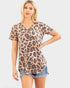 Woman wearing a leopard print top and denim shorts on a plain background
