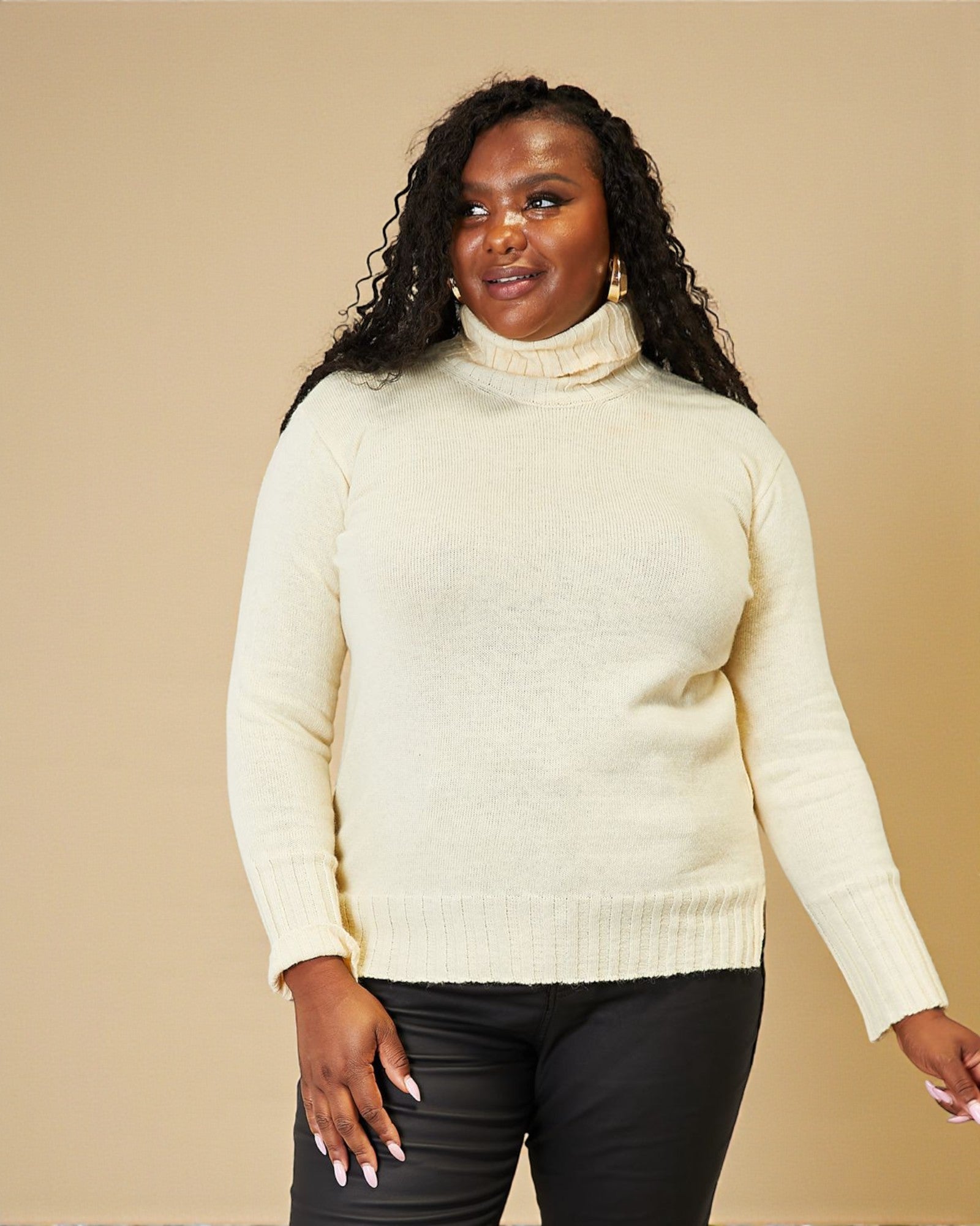 Woman wearing a cream turtleneck sweater against a beige background