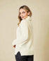 Woman wearing a cream sweater against a beige background