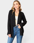 Woman wearing a black blazer and blue jeans on a white background