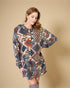 Woman wearing a patterned dress against a beige background