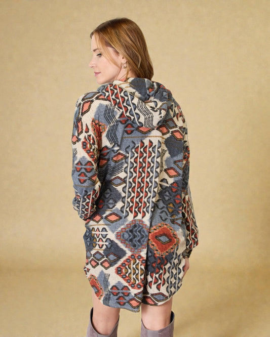 Woman wearing a patterned coat against a beige background