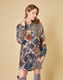 Woman wearing a patterned dress against a beige background