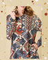 Person wearing a patterned jacket with a beige background