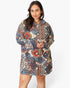 A woman modeling a long-sleeve hooded button-front jacket with a multicolor geometric tribal pattern in blue, red, beige, and black on a white studio background.