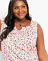 A woman wearing a sleeveless scoop-neck top with a pink, gray, and white abstract leopard print pattern, shown against a plain white background.