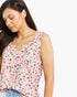A woman wearing a sleeveless pink top with a black and white leopard print pattern, shown against a plain white background.