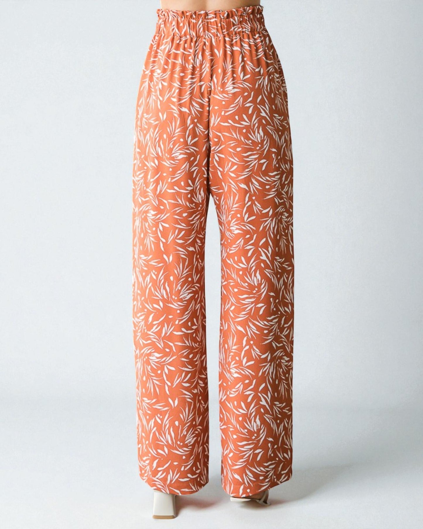 Orange pants with white leaf pattern on a white background
