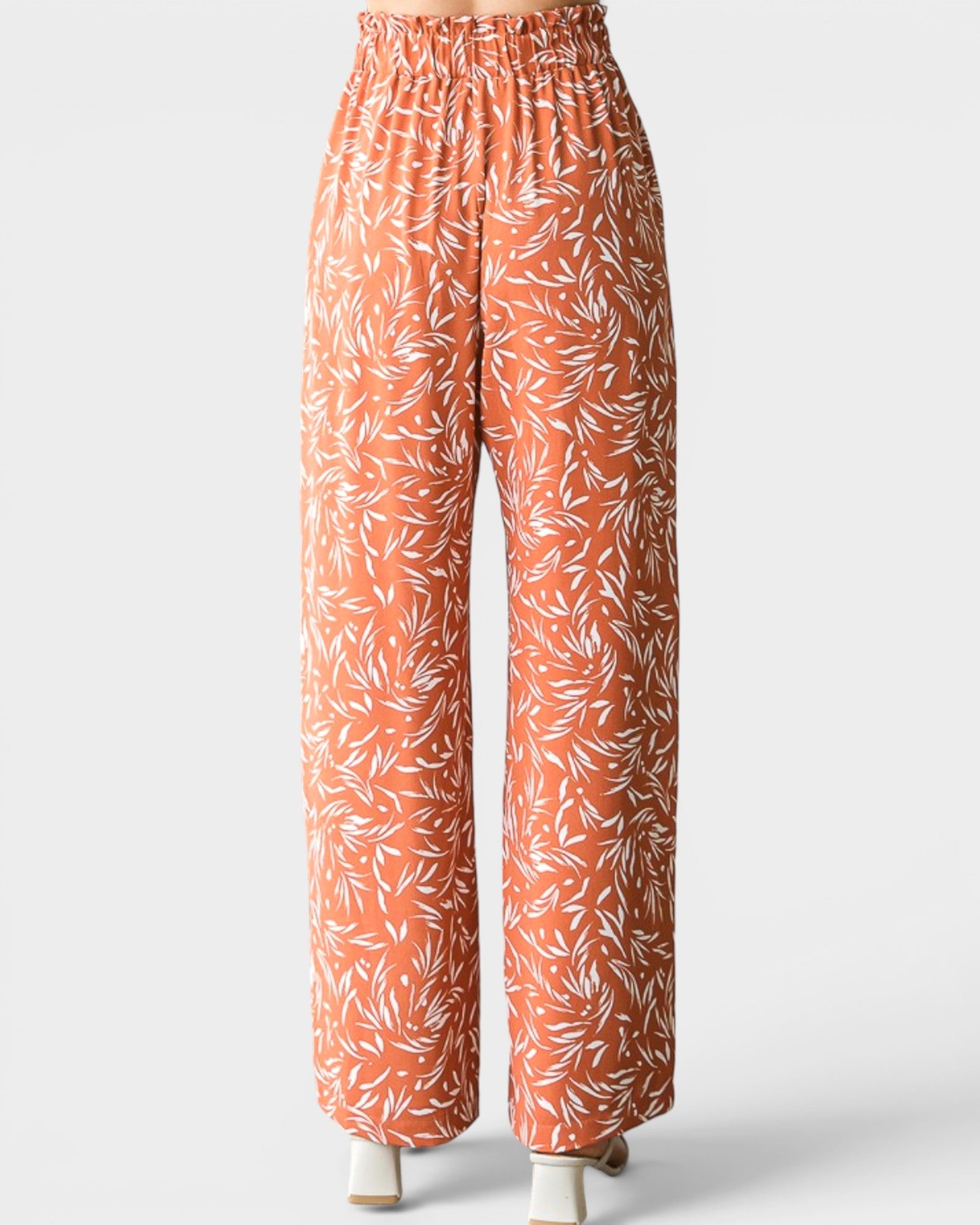 Orange pants with white leaf pattern on a white background