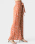 Orange floral patterned pants with a tie waist on a white background