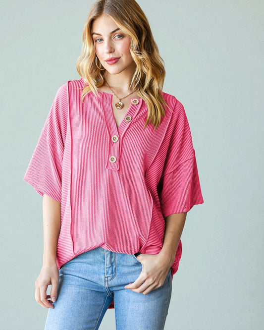 Woman wearing a pink striped shirt and blue jeans against a gray background