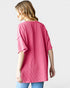 Woman wearing a pink ribbed sweater on a white background