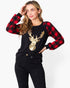 A woman modeling a long-sleeve top with a black and red buffalo plaid pattern on the sleeves and collar, paired with a black body featuring a large gold sequined deer head graphic on the chest, styled with black jeans against a plain white background.