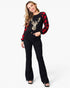 A woman modeling a black long-sleeve top with red buffalo plaid sleeves, a gold sequined reindeer graphic on the front, and black flared jeans against a plain white background.
