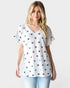Woman wearing a white t-shirt with star patterns on a plain background
