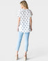 Woman wearing a white t-shirt with star pattern and light blue jeans on a white background