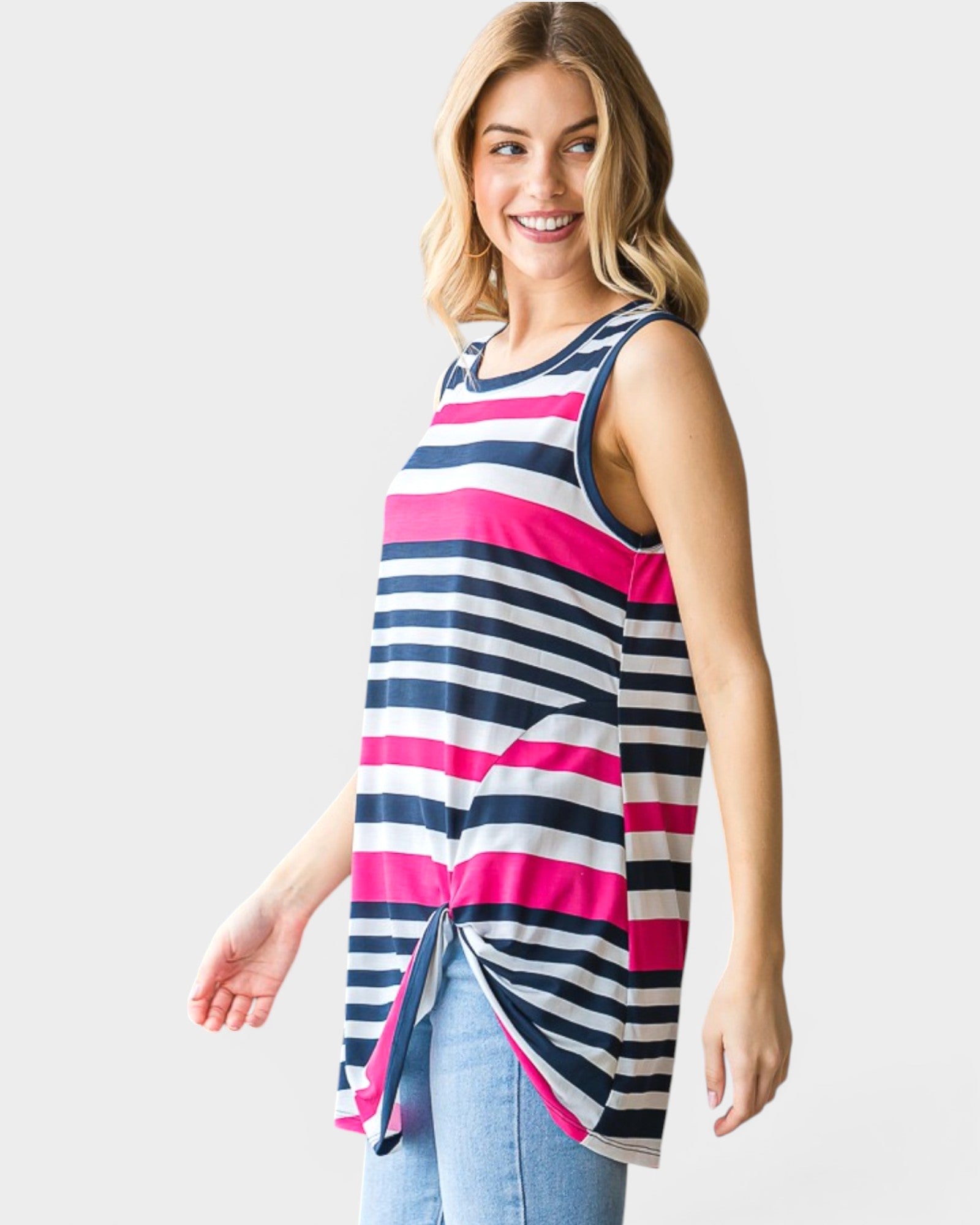 Woman wearing a sleeveless striped top with pink and blue horizontal stripes on a plain background