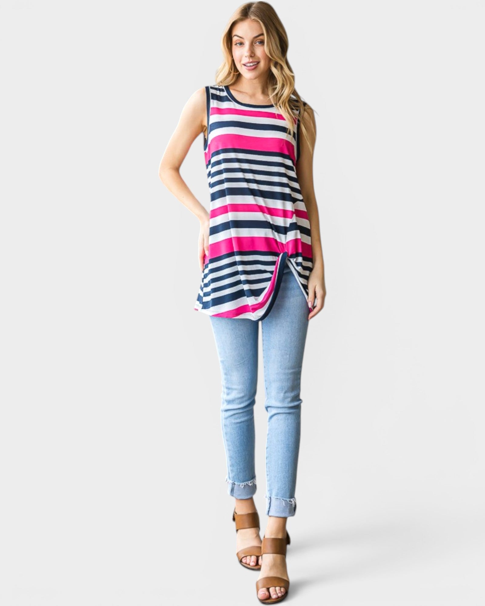 Woman wearing a striped tank top and light blue jeans on a white background