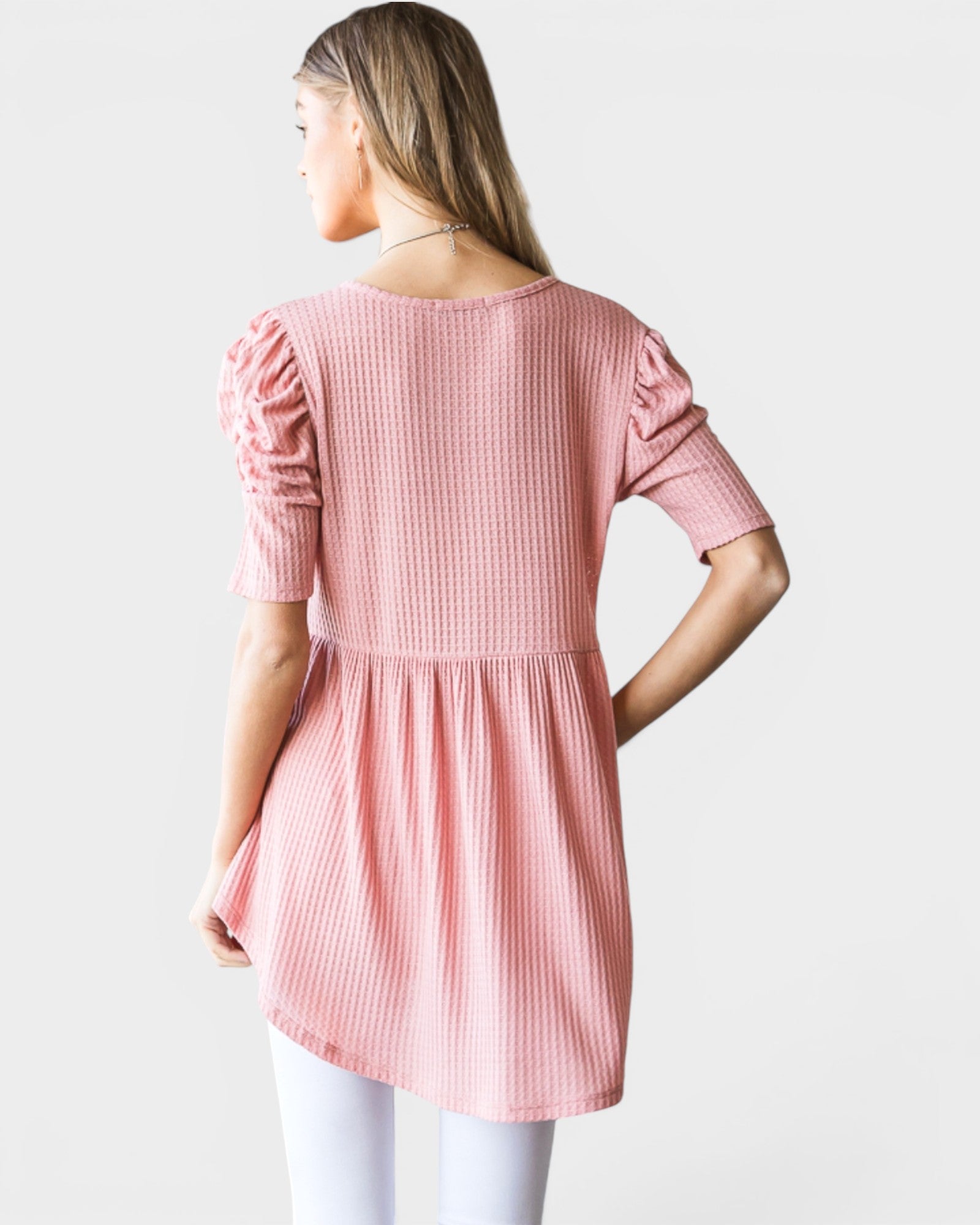 Woman wearing a pink top with a white background