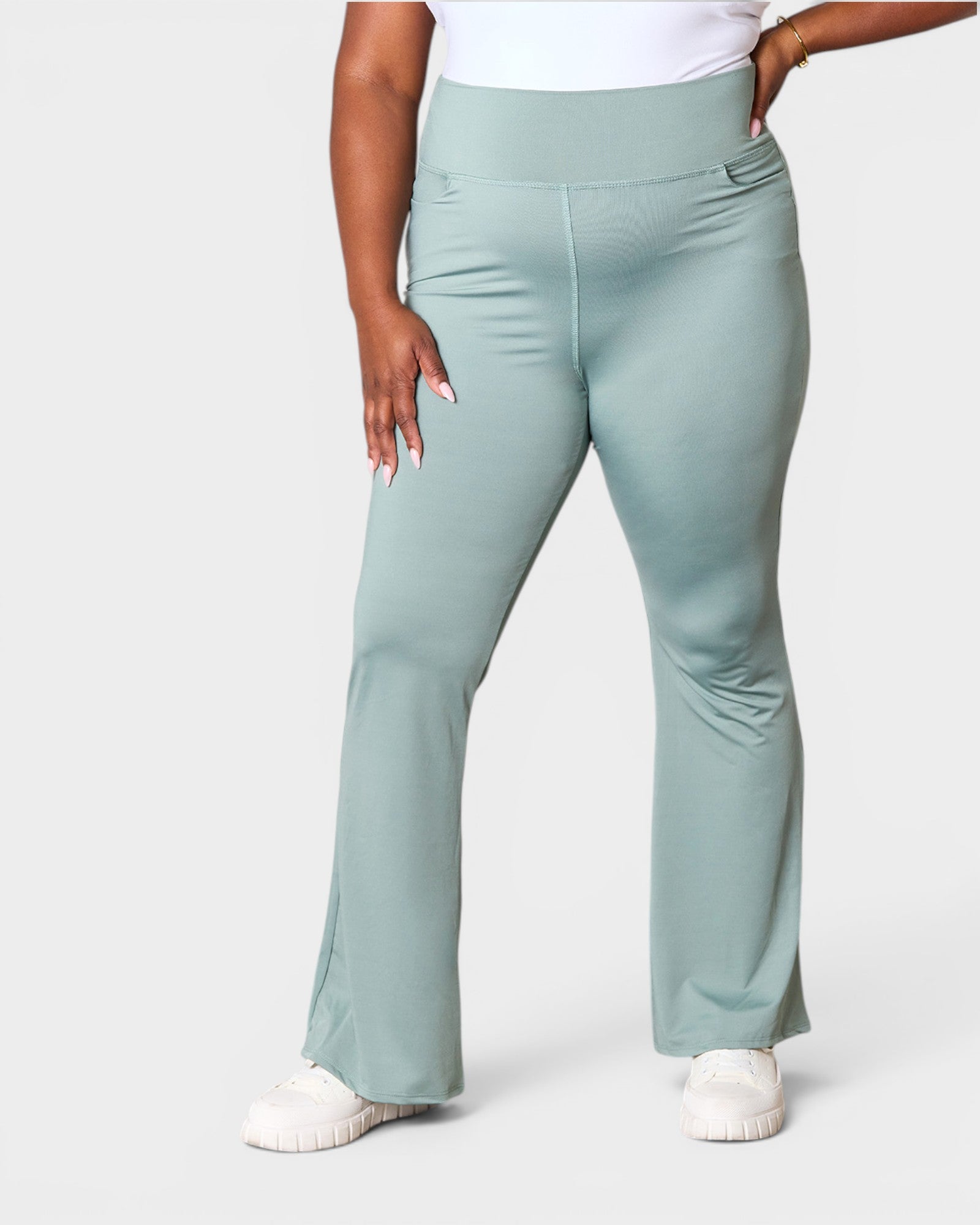 Person wearing light blue flared pants on a white background