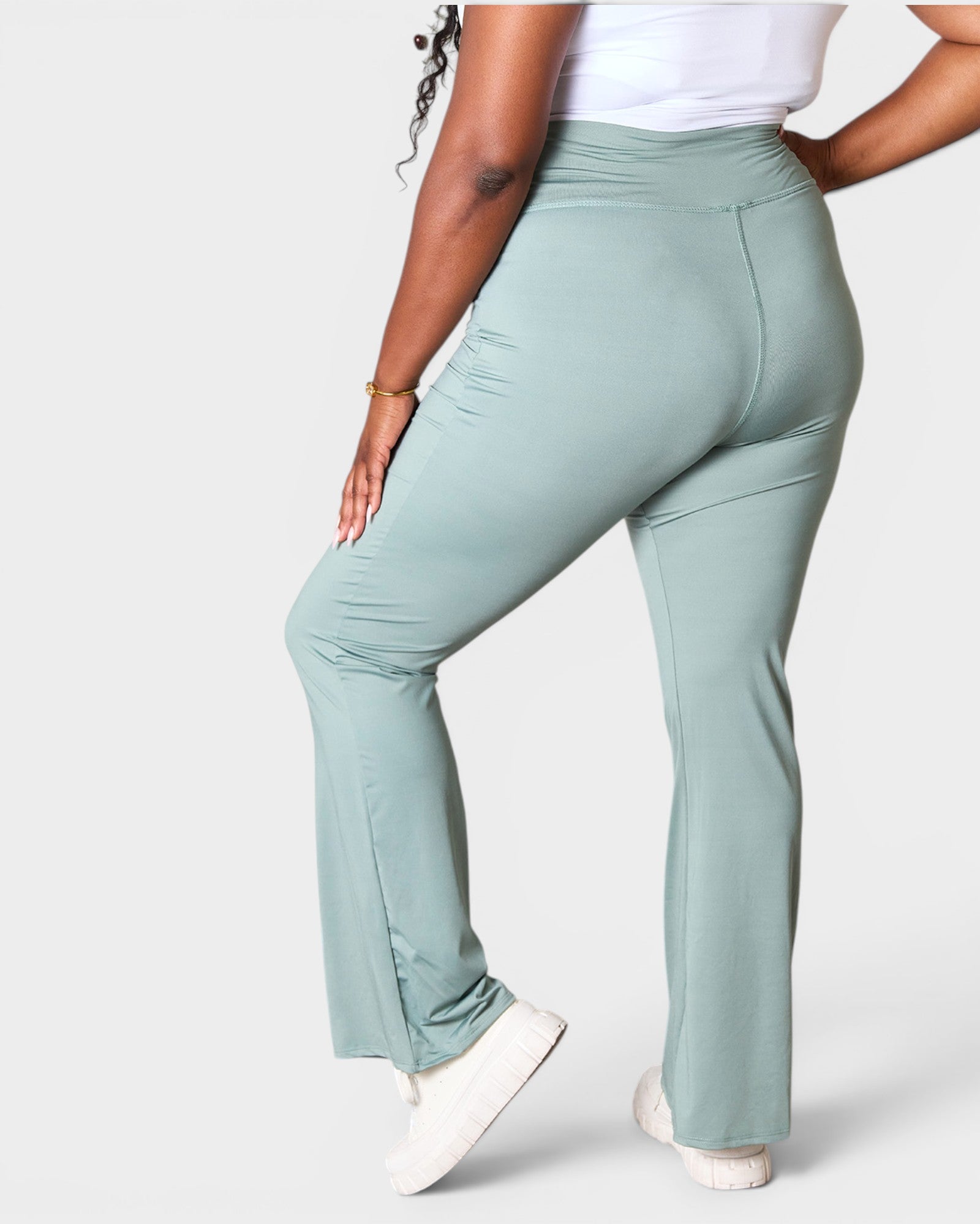 Person wearing light green pants on a white background