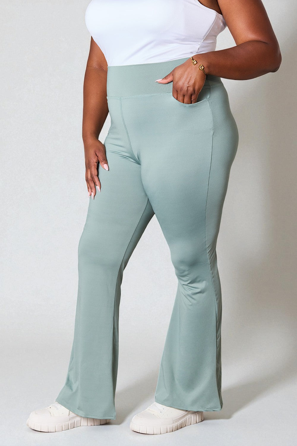 Person wearing light blue flared pants on a plain background