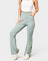 Person wearing light green pants and a white top on a plain background
